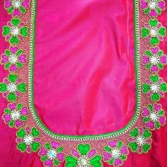 a pink and green blouse with flowers on the front, along with pearls in the back