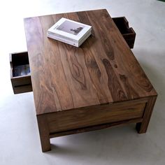 a wooden table with drawers on top and a book sitting on it's side