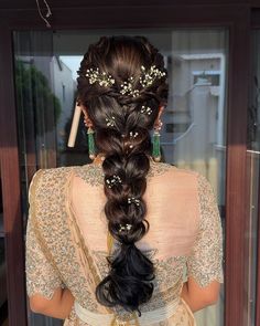 a woman with long hair in a braid and some flowers on her head is looking out the window