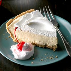 a piece of cheesecake on a plate with whipped cream and a fork next to it