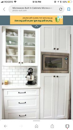 the kitchen cabinets are white and have glass doors on one side, while the rest of the cabinet door is black