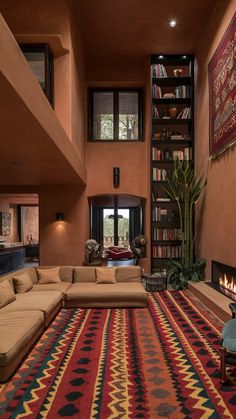 a living room filled with furniture and a fire place in the middle of it's wall