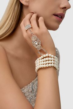 This sumptuous piece of jewelry features a retro-elegant yet slightly modern style that complements the lavish garments, reminiscent of the roaring 1920s. Features: High quality Austrian crystals and imitation pearls Four strand design Inner perimeter of bracelet is 7.4"/ 18.8cm Diameter of ring: 7"/ 2.54cm Evening Pearl Bracelet Jewelry, Elegant Jeweled Crystal Bracelet For Party, Elegant Jeweled Metal Crystal Bracelet, Pearl Embellished Party Bracelet, Elegant Jeweled Crystal Bracelet, Pearl White Bracelet Jewelry For Party, Vintage Pearl Bracelets For Parties, Vintage Pearl Jewelry With Rhinestones, Pearl Bangle Jewelry For Party