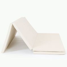 two pieces of white paper sitting next to each other on a white surface with one piece missing