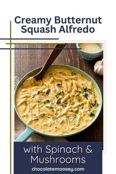 creamy butternut squash alfredo with spinach and mushrooms in a blue pan on a wooden table