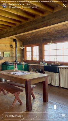 a wooden table sitting inside of a kitchen next to a stove top oven in a log cabin