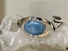 This is a stunning specimen of Leland Blue with lovely variations of blue throughout the stone. This is a specimen I found, cut and polished for this bracelet. Leland Blue is not a natural stone but rather a byproduct of smelting iron ore in the late 1800s. Blue Oval Gemstone Cuff Bracelet, Blue Bangle With Polished Finish, Formal Blue Gemstone Cuff Bracelet, Modern Blue Gemstone Bracelets, Modern Blue Gemstone Bracelet, Unique Blue Oval Cuff Bracelet, Elegant Blue Cuff Bracelet With Polished Finish, Formal Blue Bracelets With Cabochon, Blue Bangle With Natural Stones For Gift