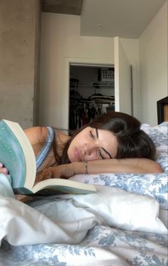 a woman laying in bed reading a book