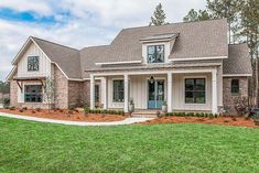 the front of a house with landscaping and grass