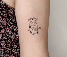 a small cow tattoo on the left side of the right arm, with an arrow in it's stomach