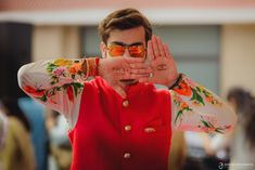 a man wearing sunglasses covering his eyes with both hands