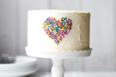 a white cake with sprinkles in the shape of a heart on top