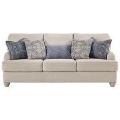 a white couch with blue and gray pillows on top of it's back end