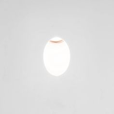 a white wall with a round light in the middle