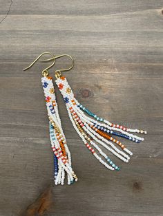 Handmade White Heishi Beads Earrings, White Bohemian Fringe Earrings, White Dangle Beaded Earrings With Tassels, White Bohemian Tassel Earrings With Tiny Beads, Bohemian White Tassel Earrings With Tiny Beads, Bohemian White Tassel Earrings With Colorful Beads, White Round Beaded Tassel Jewelry, White Beaded Fringe Long Drop Earrings, White Tassel Jewelry With Round Beads