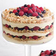 a layered cake with berries and nuts on top