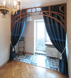 an empty room with blue curtains and chandelier