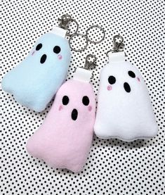 three keychains with two different colored ghost faces on them