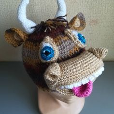 a crocheted hat with an animal's head and horns on top of it