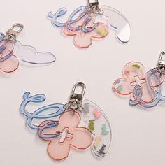 four different shaped key chains on a white surface with the word love written in it