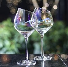 two wine glasses sitting on top of a table