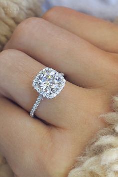 a woman's hand with a diamond ring on it