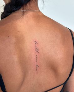 the back of a woman's shoulder with writing on it