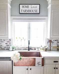 a kitchen with white cabinets and a copper sink in the center is decorated with flowers