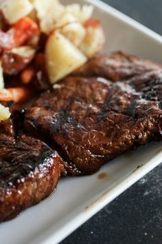 steak, potatoes and carrots on a white plate