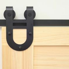 a close up of a black metal handle on a wooden door