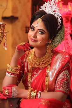 a woman in red and gold is posing for the camera