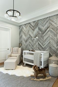 a baby's room with a white crib and gray chevron wall