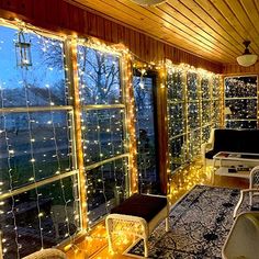 a living room filled with lots of lights next to a large window covered in curtains