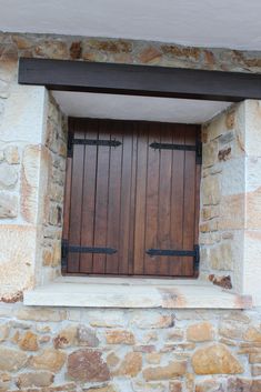 a stone building with a wooden door and window