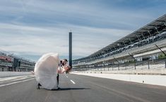 a bride and groom kissing in the middle of an empty race track