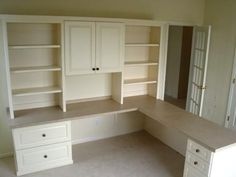 an empty room with built - in cabinets and drawers, including a countertop area