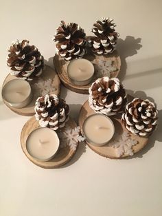 pine cones and candles are arranged on wooden trays