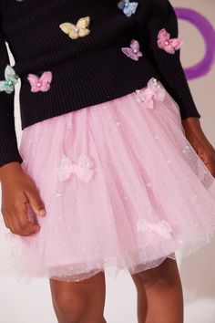 Description: Adorable pink tutu adorned with delicate bows and pearl embellishments for a charming and elegant look. Sparkling tulle fabric with star glitter details adds a touch of magic and whimsy. Elastic waistband ensures a comfortable and secure fit, perfect for twirling and dancing. Ideal for special occasions, parties, or dress-up play. Adds a delightful and girly touch to any outfit. Material & Care: Fabric: High-quality polyester tulle with bow and pearl embellishments. Care Instruction Party Tutu Dress With Pink Bow, Princess Style Tutu Dress With Pink Bow, Tulle Tutu Dress With Bow For Dress-up, Pink Ruffled Glitter Tulle Tutu Dress, Bows And Pearls, Pink Glitter Tulle Tutu Dress For Dress-up, Gigi Dress, Denim Cap, Denim Jacket Patches