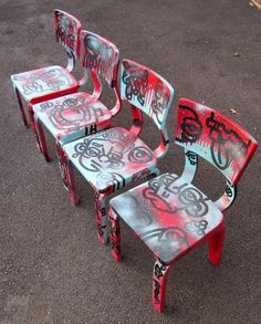 four chairs with graffiti on them sitting in the street