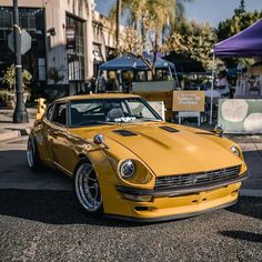 a yellow sports car parked on the side of the road in front of a building