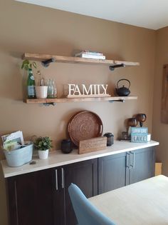 a kitchen counter with shelves above it that says family on the top and below them is a potted plant