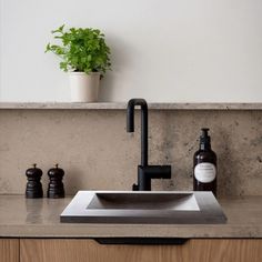 a bathroom sink with a black faucet and soap dispenser