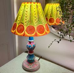 two lamps sitting on top of a table next to a potted plant