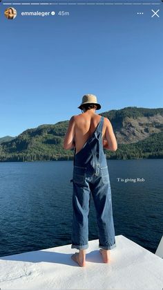 a man standing on top of a boat looking at the water