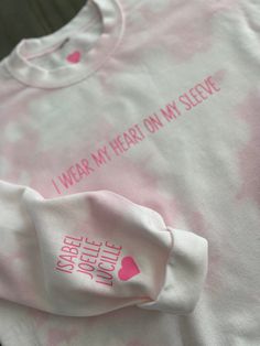 Adult crewneck sweatshirt 50/50 poly/cotton blend sweatshirt. Hand bleached pink sweatshirt with pink "I wear my heart on my sleeve” on front. Child/Children's names on sleeve with heart in PINK iron on. A personalization specialist will contact you within 1-2 business days after placing your order with your names and order for approval. THIS ITEM GETS FREE ECONOMY SHIPPING! Please note sweatshirt will not be exactly as pictured due to the hand dye process, color & pattern variations will occur. Pink Long Sleeve Sweatshirt With Heart Graphic, Pink Bleached Crew Neck Top, Pink Heart Graphic Crew Neck Sweatshirt, Tie Dye Long Sleeve Sweatshirt With Letter Print, Soft-washed Pink Cotton Sweatshirt, Pink Crew Neck Soft-washed Sweatshirt, Pink Soft-washed Crew Neck Sweatshirt, Heart On My Sleeve, Bleach Dye