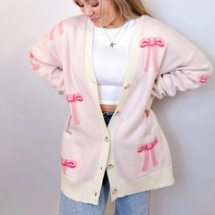 Stay Cozy And Chic With Our Oversized Bow Cardigan. Crafted From Soft, Luxurious Knit Fabric, This Cardigan Features An Effortlessly Elegant Bow Design Throughout , Adding A Touch Of Femininity To Your Look. With Its Relaxed Fit And Versatile Style, It's Perfect For Layering Over Your Favorite Tops For A Polished Yet Comfortable Ensemble. Whether You're Lounging At Home Or Stepping Out For A Casual Outing, This Cardigan Is Sure To Keep You Stylishly Snug All Day Long. Features - Front Buttons - Pink V-neck Cardigan For Loungewear, Feminine Sweater For Winter Day Out, Feminine Winter Sweater For Day Out, Feminine Sweater For Day Out In Winter, Casual Pink Long Sleeve Cardigan, Casual Long Sleeve Pink Cardigan, Cozy Pink V-neck Outerwear, Chic Pink V-neck Cardigan, Trendy Pink V-neck Outerwear