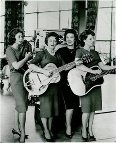 black and white photograph of three women holding guitars