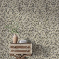 a small table with a vase on top of it next to a wallpapered wall