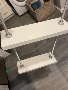 a white shelf sitting on top of a wooden floor next to a dryer and toilet