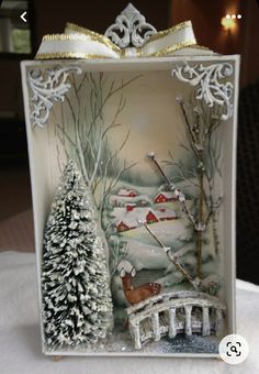 a small glass box with an image of a snowy scene and trees in the background